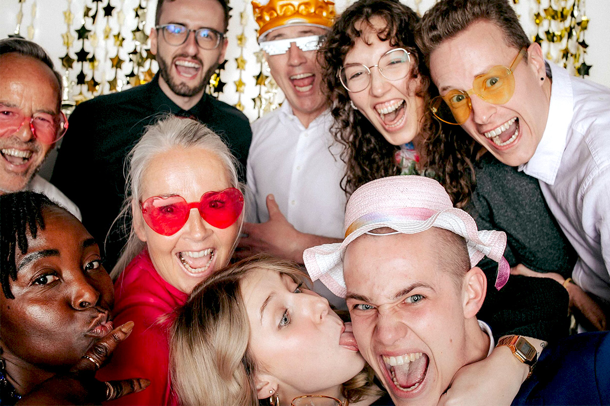 Lachende Gruppe macht Foto mit Fotobox