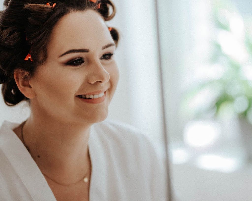 Braut mit fertigem Makeup lächelt