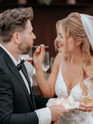 Braut gibt Bräutigam ein Stück Hochzeitstorte