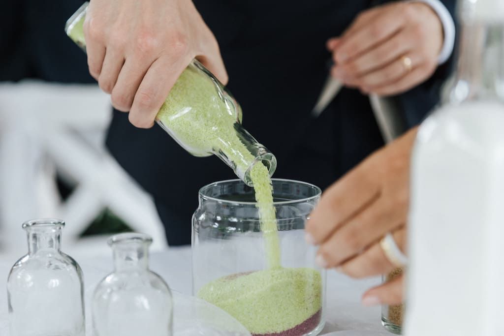 Bunter Sand wird in Glas gekippt