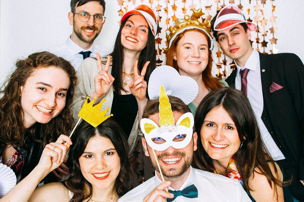 Gruppe von Personen mit Accessoires vor Fotobox