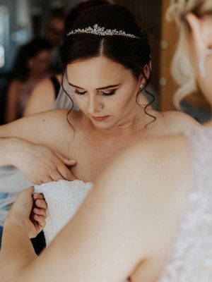 Braut zieht Hochzeitskleid an