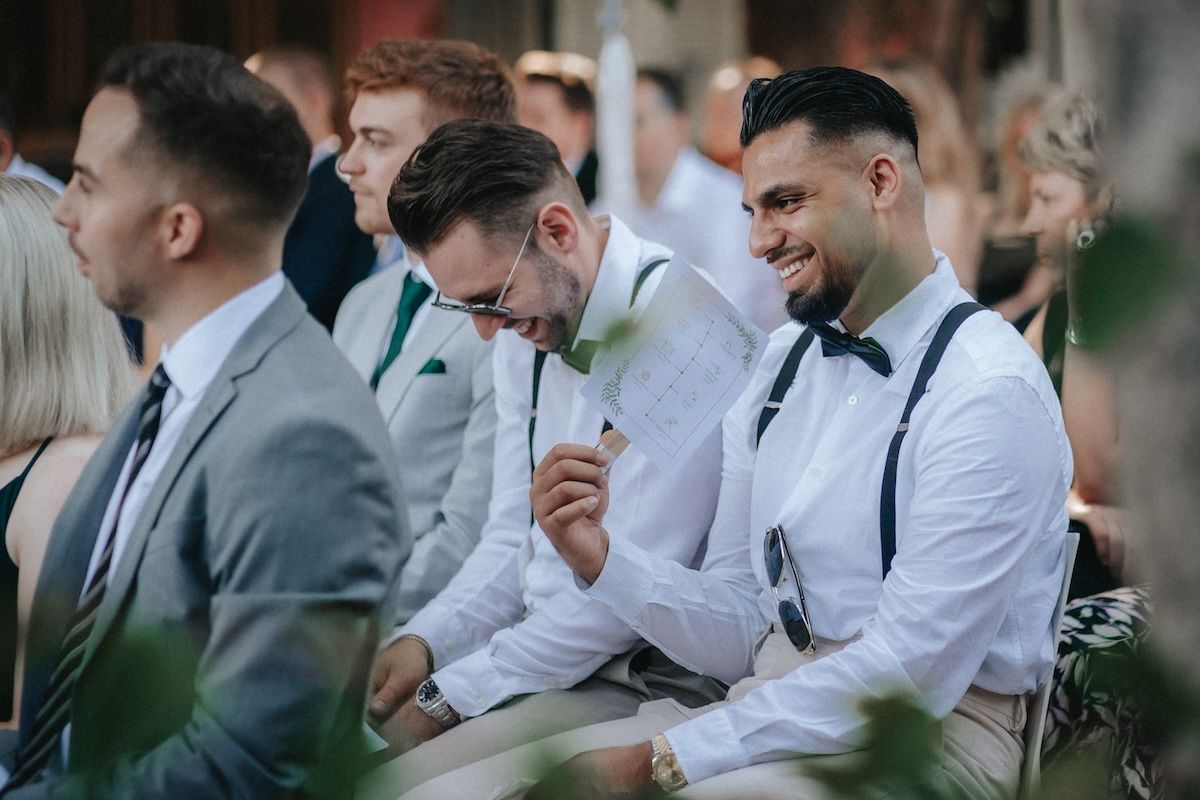 Hochzeitsgäste lachen bei der Trauung