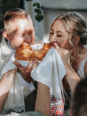 Braut und Bräutigam beißen in Hochzeitsbrot